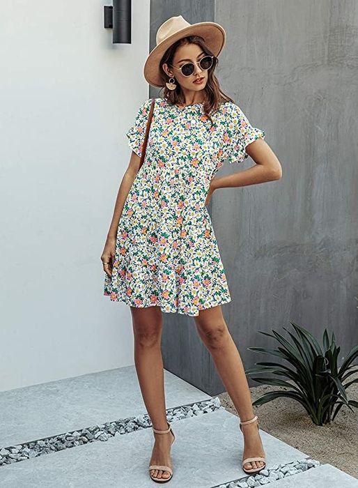 A model donning a short-sleeve floral dress, paired effortlessly with strappy sandals.