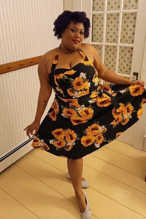 The dress in black adorned with a sunflower print