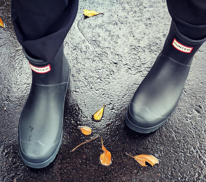 A reviewer wearing short black Hunter rain boots