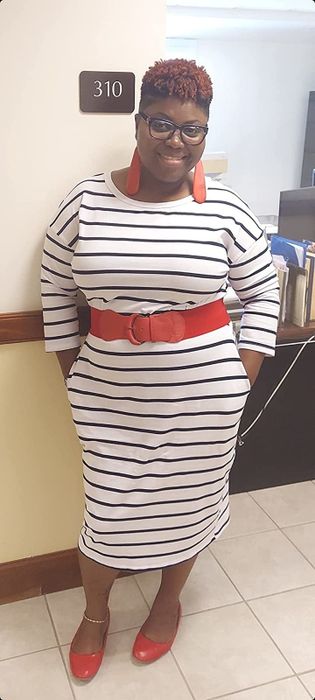 A reviewer models a white stripe dress, offering her insights on the chic design.