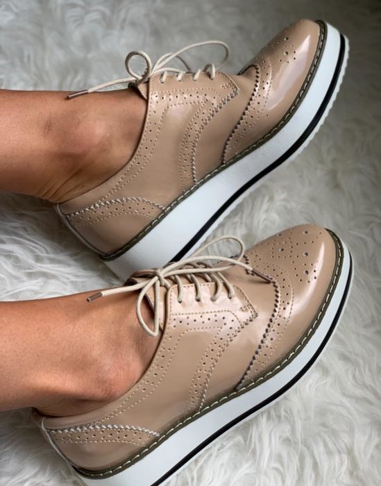 A reviewer’s photo of a pair of feet dressed in tan platform oxfords.