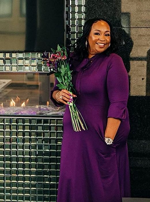 The reviewer is seen in a purple dress.