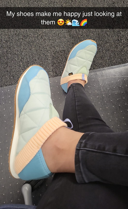 A person sitting with crossed legs, wearing trendy, quilted slip-on sneakers. Overlay text reads,