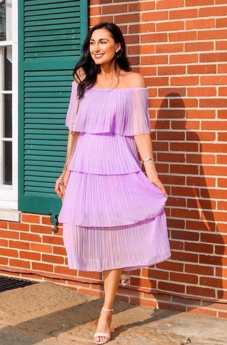 A reviewer in a purple dress shares their experience.