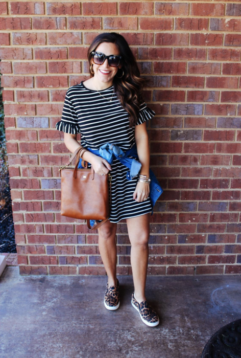 A reviewer wearing a striped T-shirt dress with ruffled details on the sleeves.