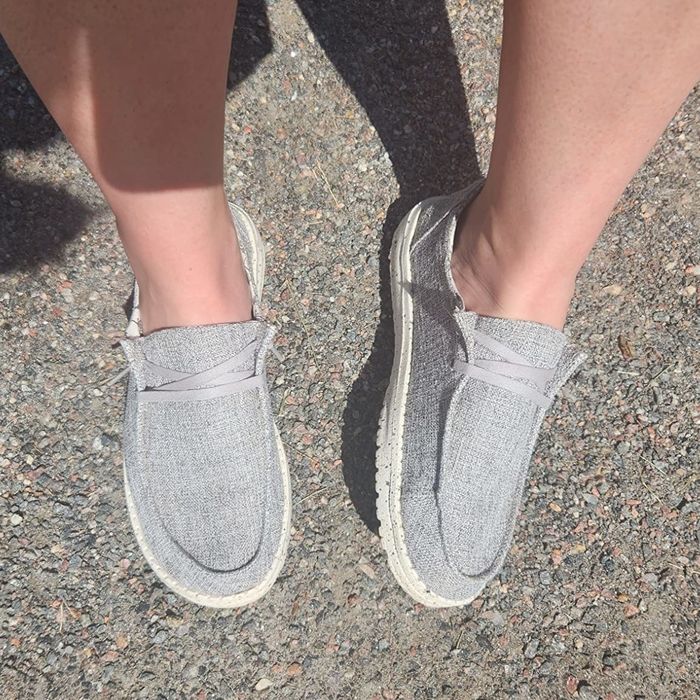 A reviewer is wearing shoes in a soft light gray shade.