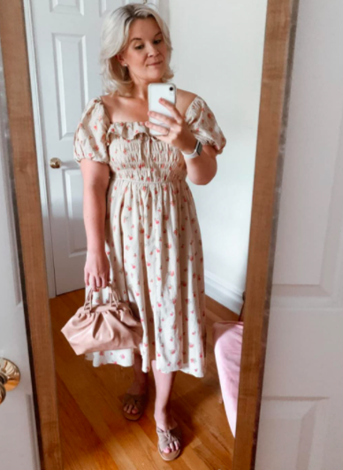A customer review photo of them taking a mirror selfie while wearing the dress, highlighting its flattering fit