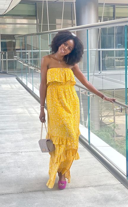 The reviewer is seen wearing a yellow dress.