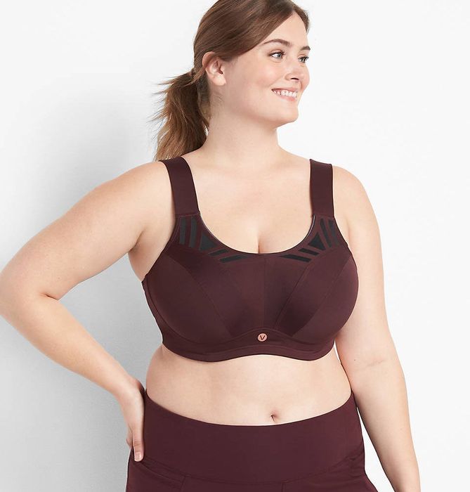 The model is wearing a maroon sports bra paired with matching leggings.