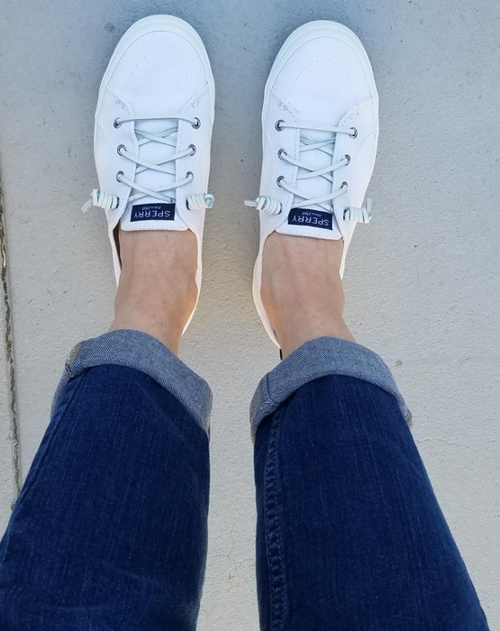 The reviewer's feet are adorned in fresh white sneakers.