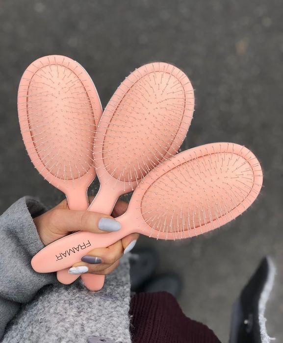 A hand holding three pink hairbrushes with 'Ramar' branding, ideal for detangling hair, showcased in a shopping article.