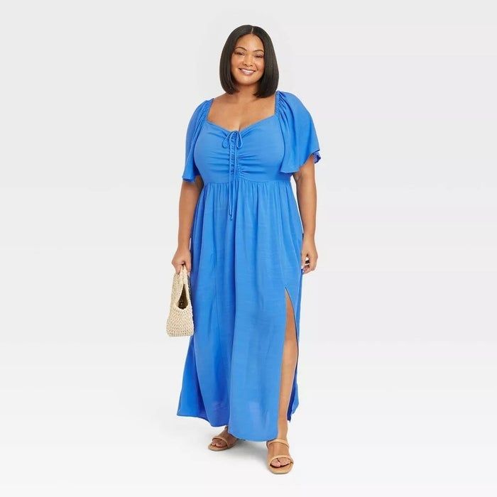 A model wearing a bright blue dress with a front bow-tie
