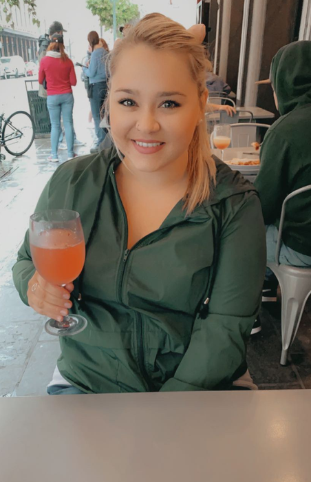 A reviewer seated, sporting a dark green windbreaker.