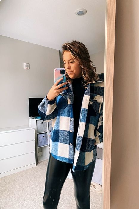 A reviewer showing off the blue and white version of the jacket, left open for a relaxed look.