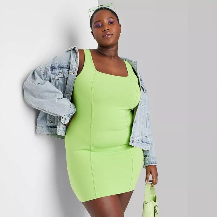 A model in a vibrant highlighter green bodycon dress