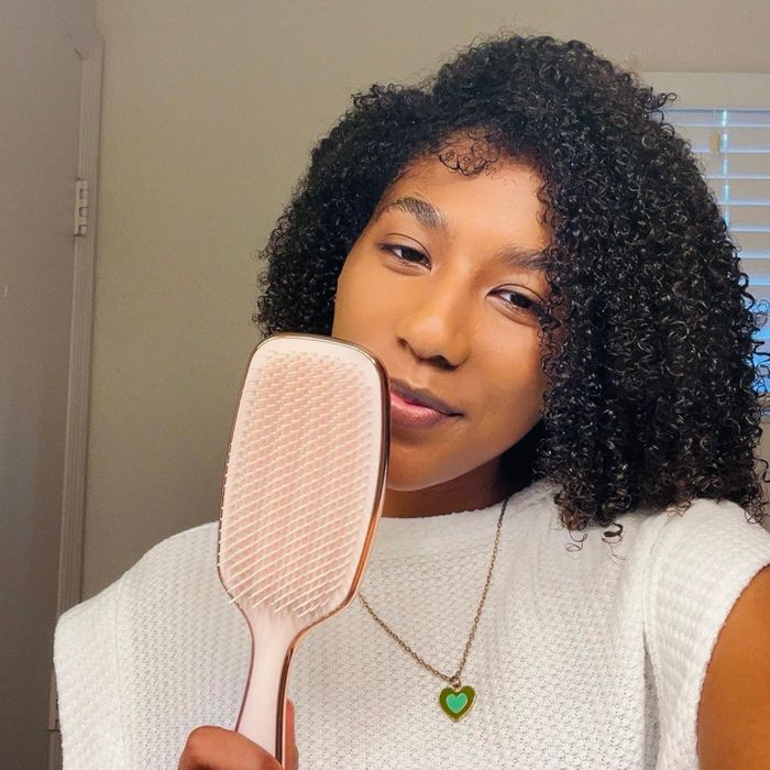A reviewer holding the rose gold brush
