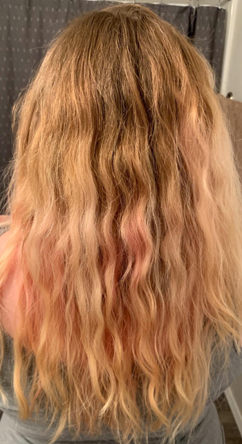 The same reviewer's hair looking smoother and more defined after using the product