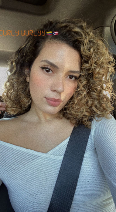 A reviewer showing off their curly hair