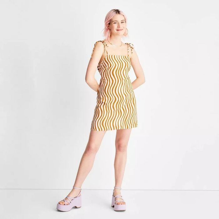 A model in the saffron and white wavy striped dress
