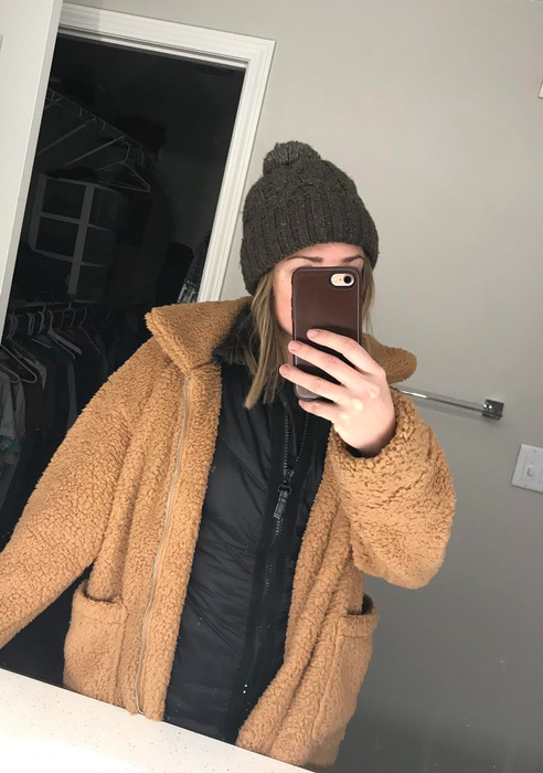 A reviewer wearing the jacket in khaki with a zipper closure.
