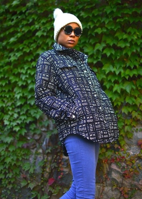 A model wearing a black quilted jacket with delicate white pattern accents.