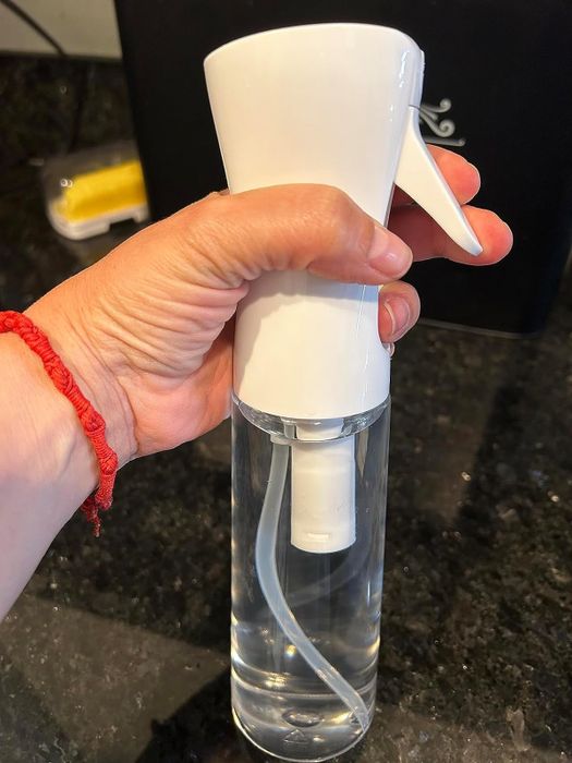A reviewer holding the spray bottle in their hand.