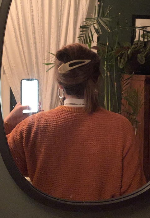 A reviewer demonstrates how they styled their hair with the white curved clip.