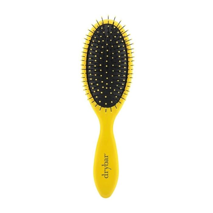 Yellow Drybar brush with black bristles, specifically designed to smooth and detangle hair