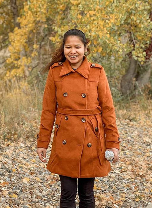 A reviewer captured wearing the orange peacoat surrounded by fall foliage.