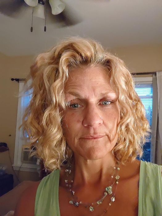 A reviewer sporting frizz-free, curly, blonde hair.