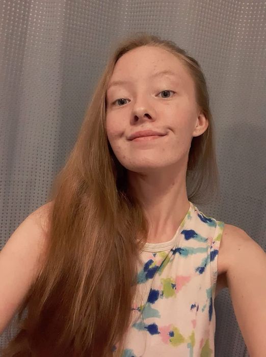 A reviewer with long, straight, shiny red hair