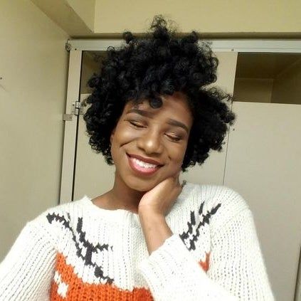 The same reviewer with voluminous curls in their hair after using the foam rods (type 4C hair)