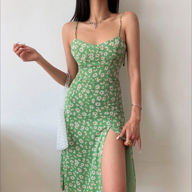 Model wearing a spaghetti strap dress with a thigh-high slit.
