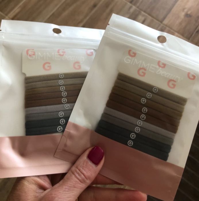 Reviewer holding two packs of the nude combo hair ties
