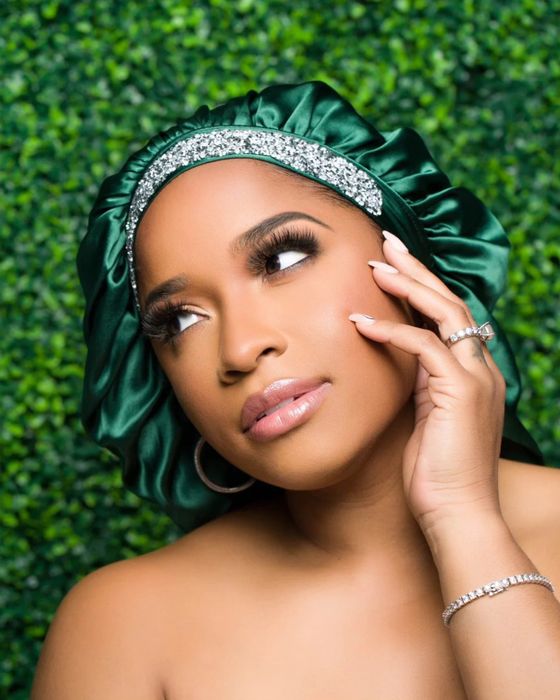 A model showcases the emerald silk bonnet.