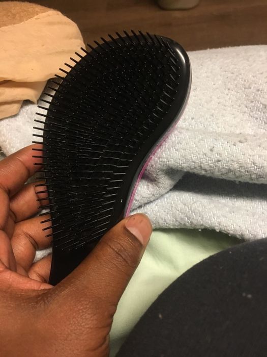 A reviewer holding up the brush, showcasing the bristled side.