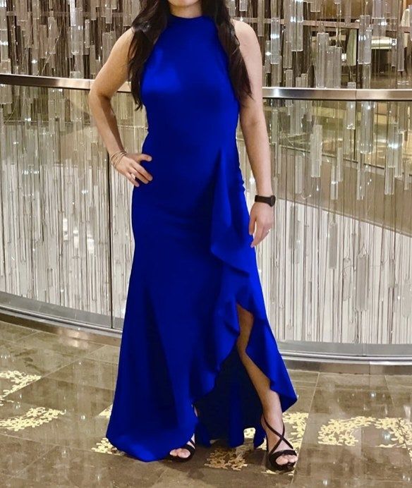 A reviewer wearing a floor-length blue dress