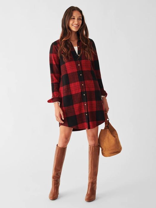 The model is styled in a red and black plaid tunic, paired with brown boots.