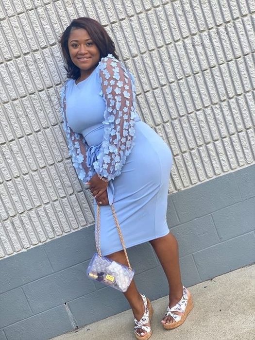 A reviewer wearing the mid-length dress in blue