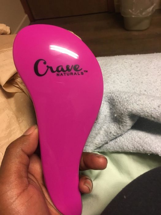 Holding up the pink side of the brush.