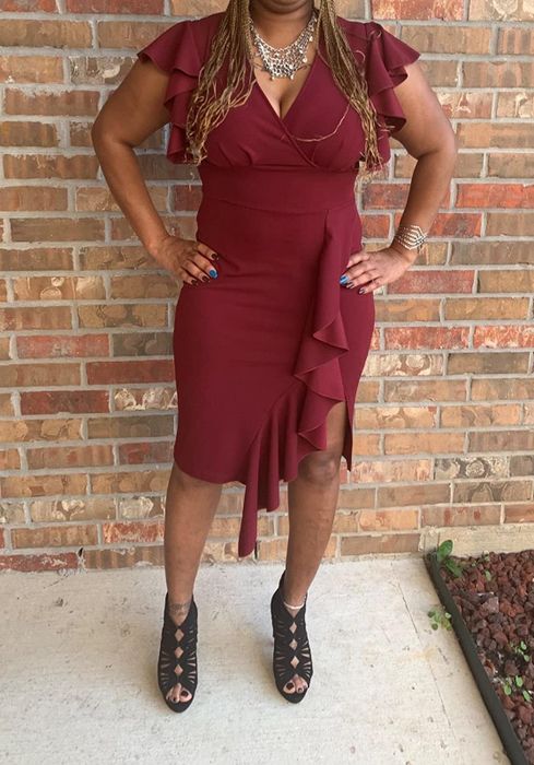 A reviewer sporting a red slit ruffle dress