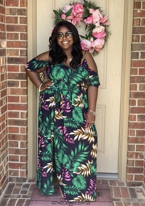 A reviewer wearing a palm print floor-length dress