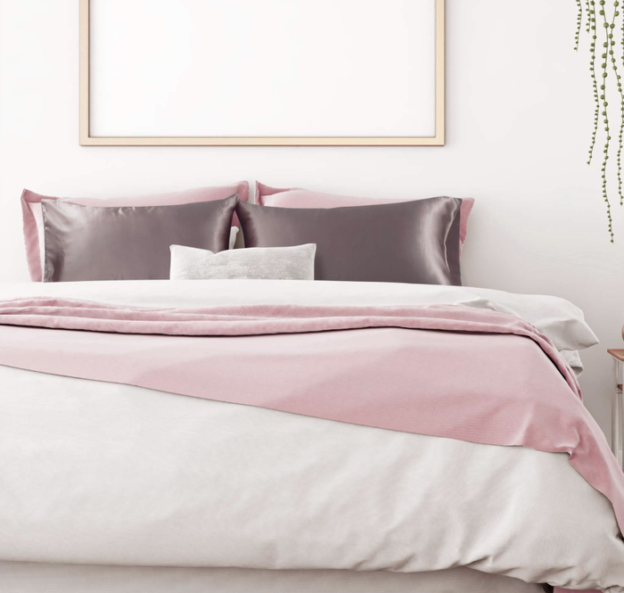 The gray satin pillowcases resting on pillows on a bed