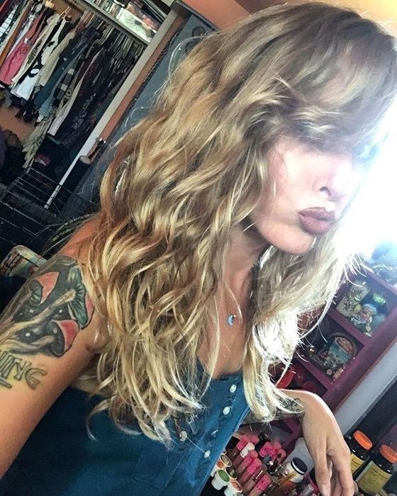 The reviewer showing off their curls after using the spray