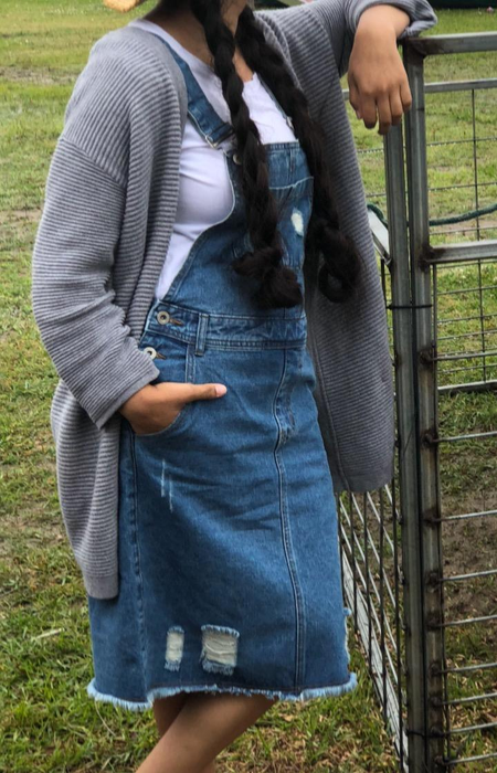 A reviewer in a blue denim dress paired with a gray sweater