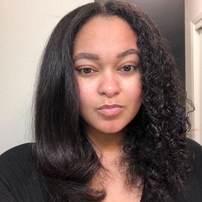 Reviewer showing their straightened hair after using the hot air brush on tight curls