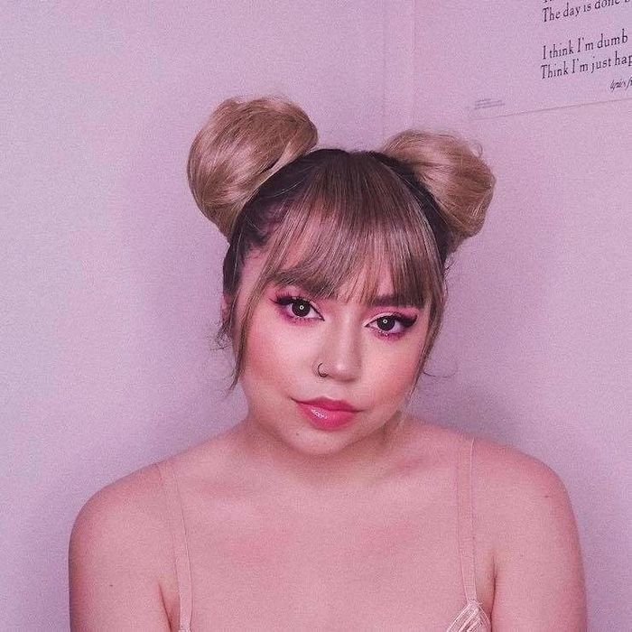 Space buns styled in brown hair.