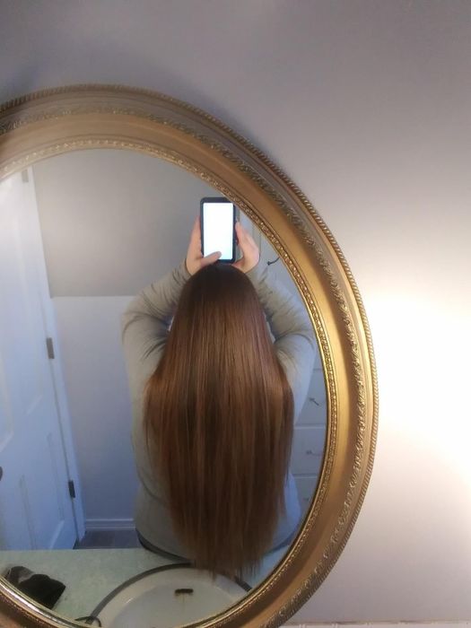 The reviewer with glossy, frizz-free hair after using the L'Oreal Paris treatment