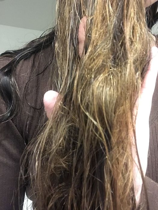 A reviewer's photo showing their hair before using the detangling spray.
