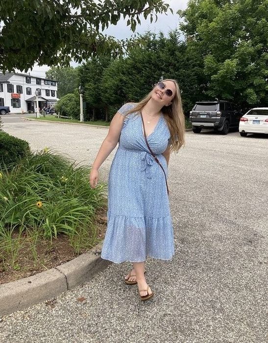 A reviewer wearing the dress in blue